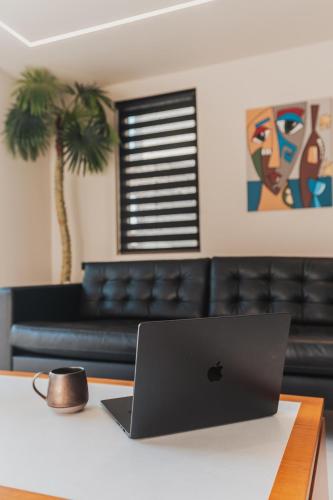 a laptop computer sitting on a table with a couch at Nos Aqua Villas Chania in Pazinos