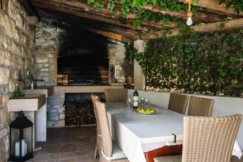 a table with chairs and a fireplace in a patio at Villa matulic in Postira