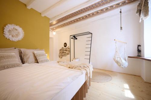 a bedroom with a large white bed with yellow walls at Villa Porta no in Bale