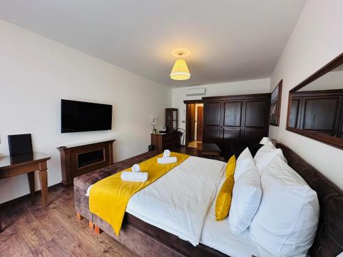 a bedroom with a bed with a yellow blanket on it at Parkhotel Brno in Brno