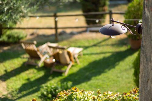 a lamp in a garden with a table and benches at Vivaia Trendy Rural in Poggibonsi