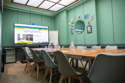a conference room with a long table and a projection screen at Hôtel Royal in Montpellier