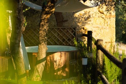 a fence with a tree in front of a building at Vivaia Trendy Rural in Poggibonsi