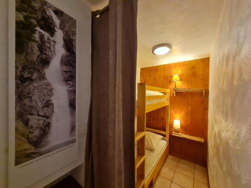 Cette petite chambre comprend des lits superposés et un couloir. dans l'établissement Les Chalets d Or - B03 - Appt terrasse 4 pers, à Les Deux Alpes
