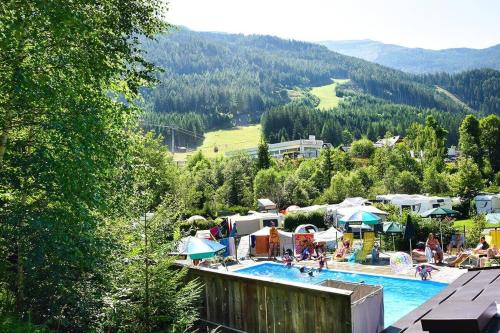 a resort with a swimming pool with people in it at Campingplatz Mauterndorf in Mauterndorf