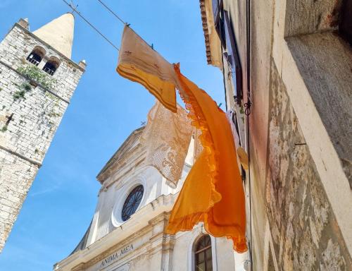 an orange flag hanging from a building with a clock tower at Villa Porta no in Bale