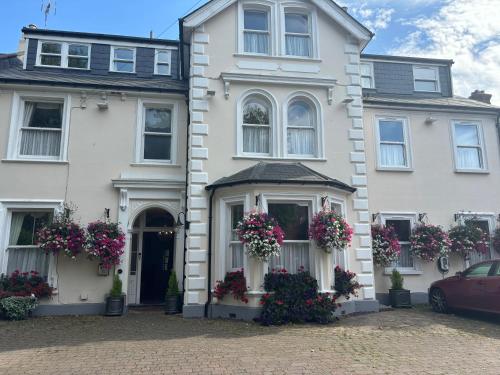 a white house with flowers in front of it at canterbury lodge in Kent
