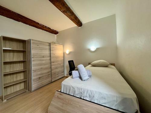 une chambre avec un lit et une étagère dans l'établissement Le Refuge du Coquelicot, à Béziers