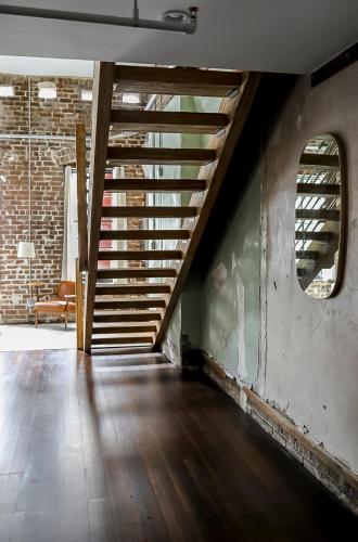 an empty room with a staircase and a couch at The Grant by Black Swan in Savannah