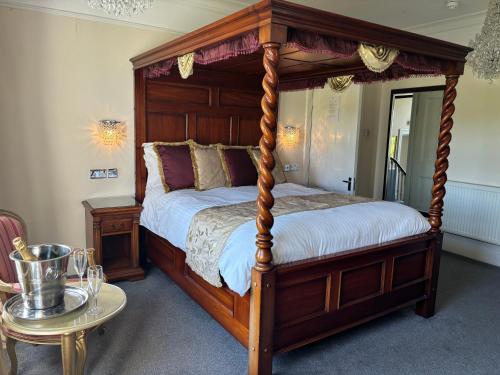 1 dormitorio con cama con dosel y mesa en canterbury lodge, en Kent