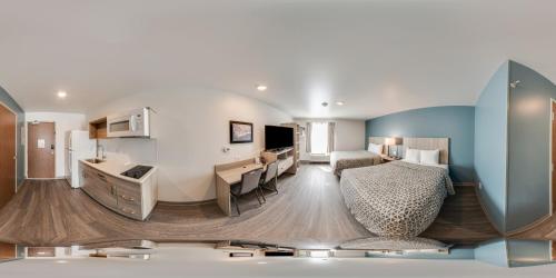 a hotel room with a kitchen and a bedroom at WoodSpring Suites Grand Rapids Kentwood in Grand Rapids