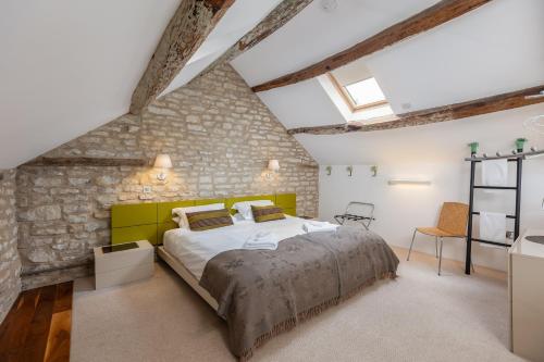 a bedroom with a large bed and a stone wall at Noelle’s Cottages, The Barn in Pickering