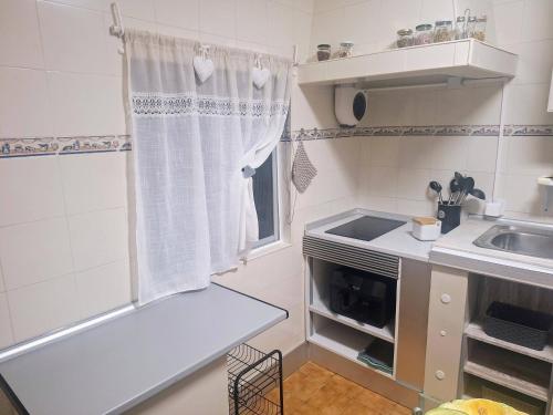 a small kitchen with a sink and a window at Casa dos pais in Crato