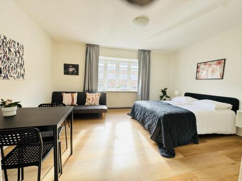 a bedroom with a bed and a dining room at aday - Beautiful and Cozy Studio Apartment in Aalborg