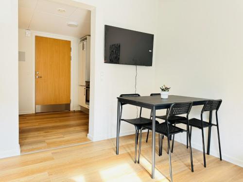 a dining room with a black table and chairs at aday - Beautiful and Cozy Studio Apartment in Aalborg