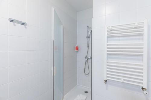 a white bathroom with a shower and a toilet at Appart'City Confort Orléans in Orléans