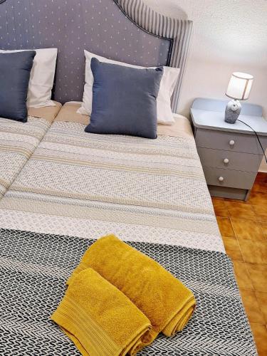a bed with a yellow blanket on top of it at Casa dos pais in Crato
