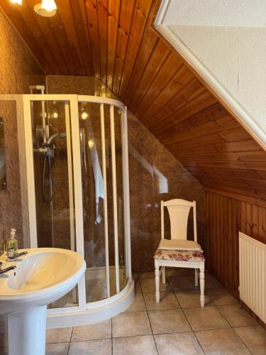 ein Badezimmer mit einem Waschbecken und einem Stuhl in der Unterkunft Glengorm Guest House in Oban