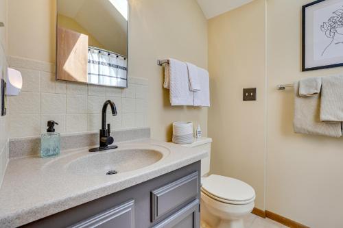 a bathroom with a sink and a toilet and a mirror at Indoor Pool Access and Deck Galena Family Getaway! in Galena