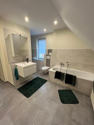a bathroom with a tub and a sink and a toilet at Ferienwohnung Lange in Kalbe