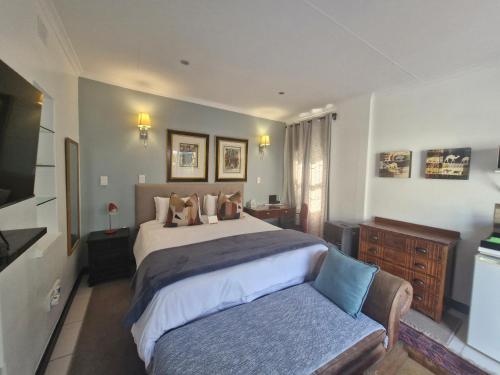 a bedroom with a large bed and a couch at B&B on Buckingham Guest House in Johannesburg