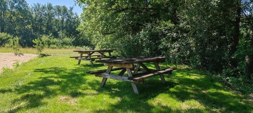 two picnic tables sitting in the grass in a field at Village Bord de Ciel in Caylus
