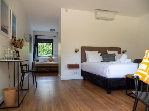 a bedroom with a bed and a table and chairs at La Coudraie - Proche de Disneyland in Montévrain