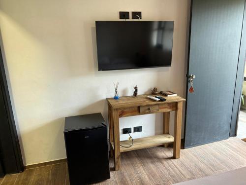 a room with a table with a television on a wall at Pousada Villa Tropea - Fazenda Chapadão in Serra Negra