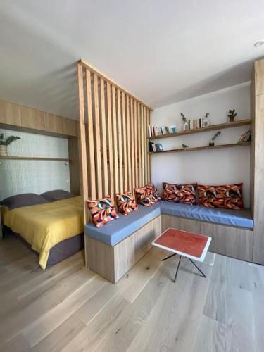 a bedroom with a bed and a bench and shelves at Studio avec terrasse in Nontron