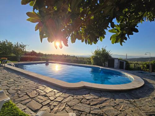 a swimming pool in a yard with a stone walkway at Quinta da Malafaya in Nogueira