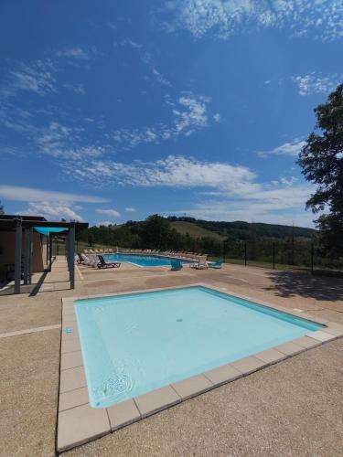 a large blue swimming pool in a yard at Village Bord de Ciel in Caylus