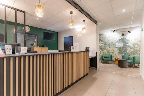 a lobby of a waiting area with green chairs at Appart'City Confort Orléans in Orléans