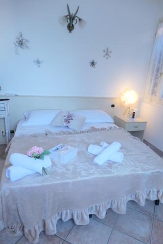 a bedroom with a white bed with flowers on it at B&B Luna in Castelvetro di Modena