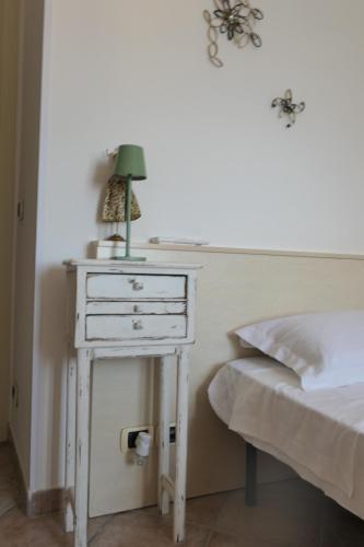 a nightstand with a lamp on it next to a bed at B&B Luna in Castelvetro di Modena