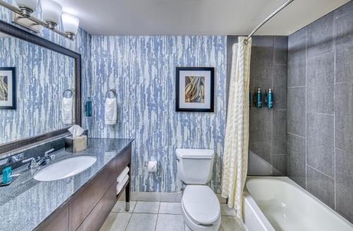 a bathroom with a toilet and a sink and a tub at DoubleTree by Hilton Port Huron in Port Huron