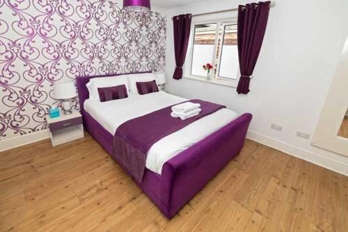 a bedroom with a purple bed in a room at G Boutique Hotel in Portsmouth