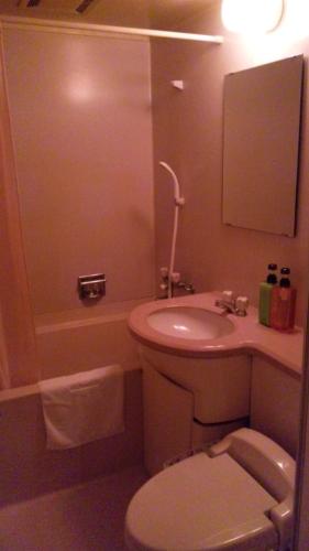 a bathroom with a toilet and a sink and a tub at Hotel Takamatsu Hills in Takamatsu