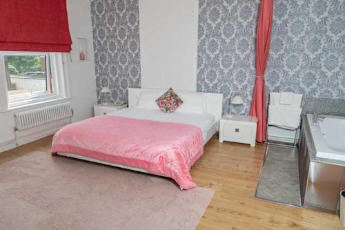 a bedroom with a white bed with a pink blanket at G Boutique Hotel in Portsmouth