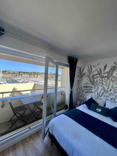 une chambre avec un lit et un balcon avec vue dans l'établissement Escale sur le port de Dahouet avec vue sur mer, à Pléneuf-Val-André