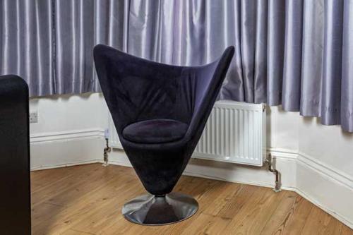 a black chair sitting on top of a wooden floor at G Boutique Hotel in Portsmouth