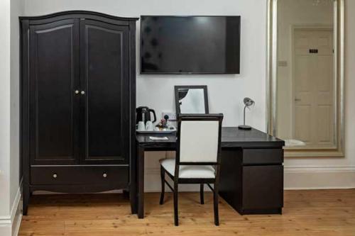 a desk with a chair next to a black cabinet at G Boutique Hotel in Portsmouth