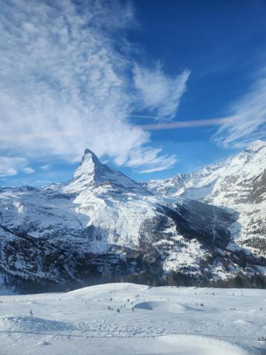 a mountain covered in snow with a blue sky at Sky Haus Residence in Täsch
