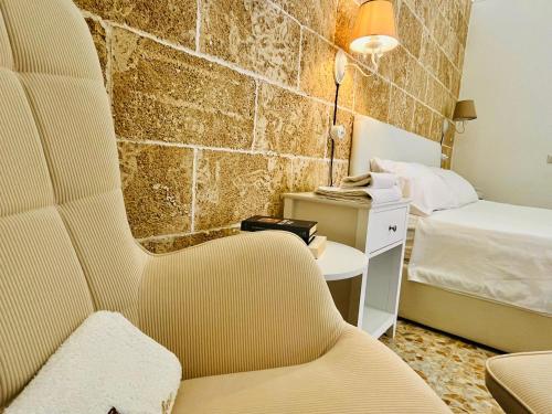 a hotel room with a chair and a bed at Corte Gabellone - dimora storica in Nardò