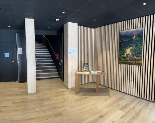 a hallway with a table and stairs in a building at Hôtel du Puy Ferrand , Restaurant La Table de l'Ours in Le Mont-Dore