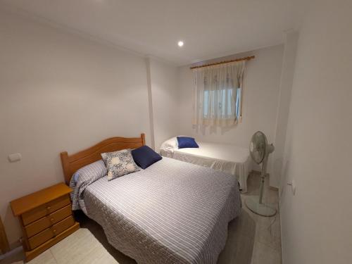 a bedroom with two beds and a fan at Apartamento frente al mar 4 habitaciones in Oropesa del Mar
