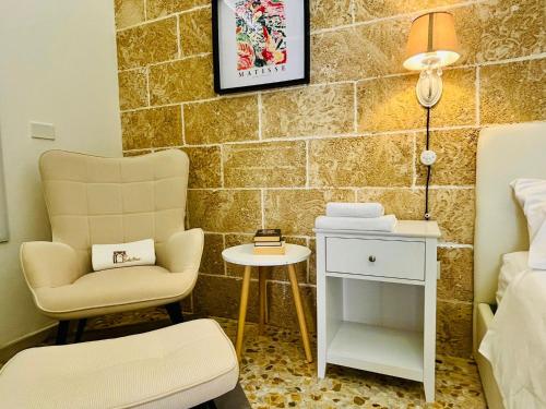 a room with a bed and a chair and a table at Corte Gabellone - dimora storica in Nardò