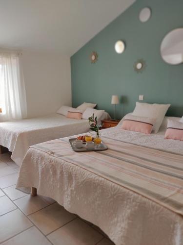 Cette chambre comprend 2 lits et un plateau de fruits sur une table. dans l'établissement Gîte du Domaine de Coutancie, à Prigonrieux