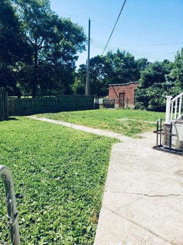 a grassy yard with a white bench and a fence at Entire Private STL Apartment - 51A in Carondelet
