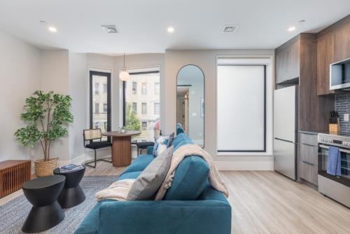 a living room with a blue couch and a kitchen at Symphony Suites by Thatch in Boston
