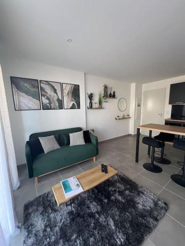 un salon avec un canapé vert et une table dans l'établissement Appartement de la plage, à Solaro